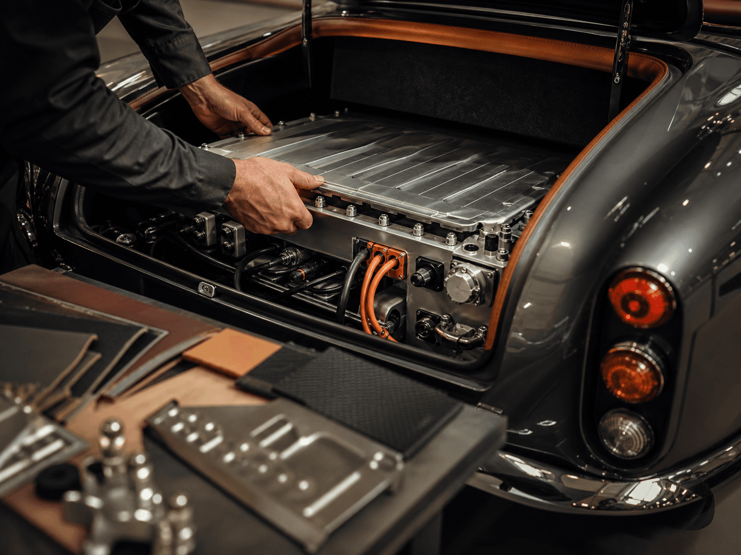 Technician fitting an EV battery module into a classic car